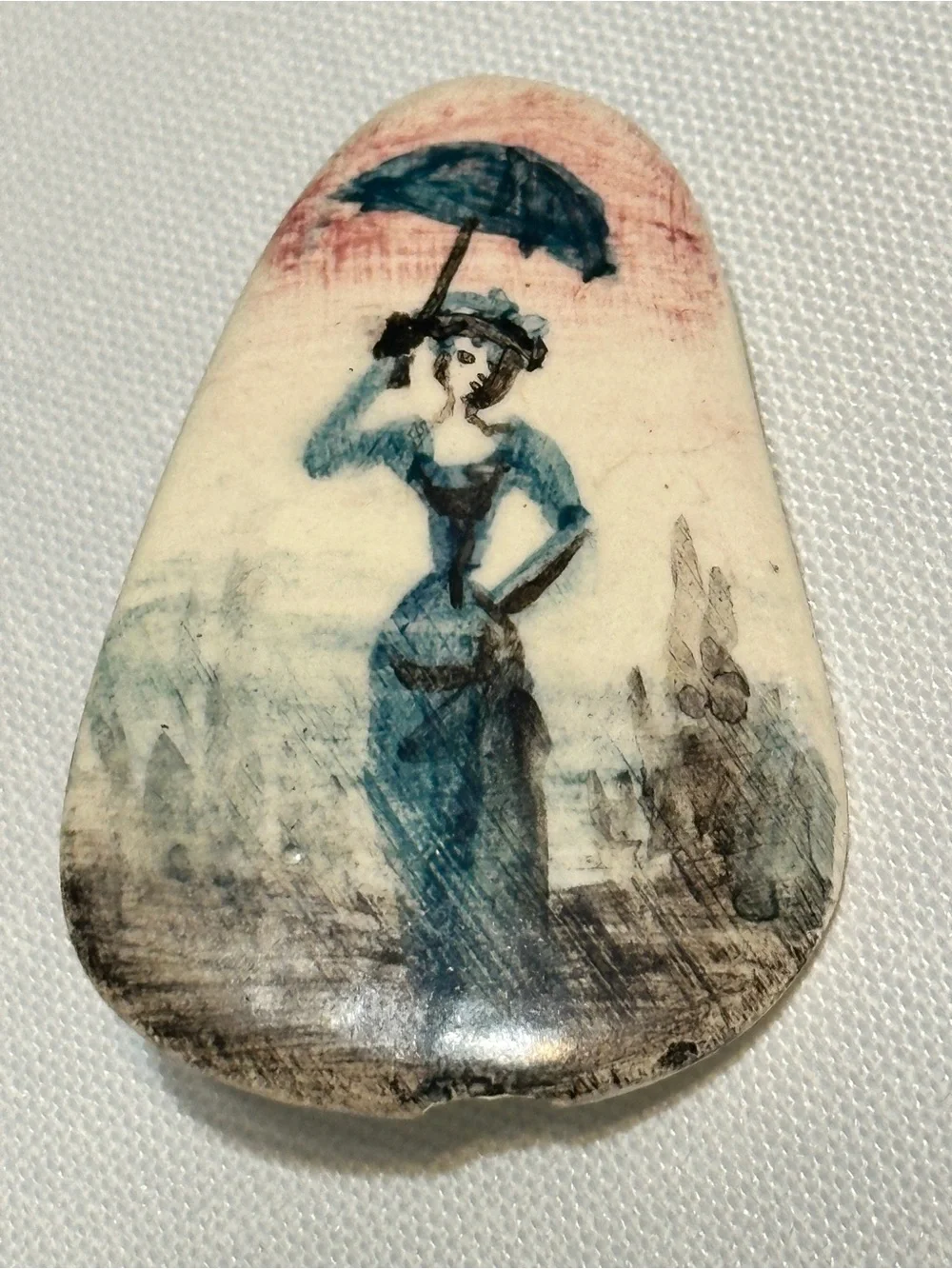Small, hand-painted miniature artwork on a smooth stone or ceramic cabochon